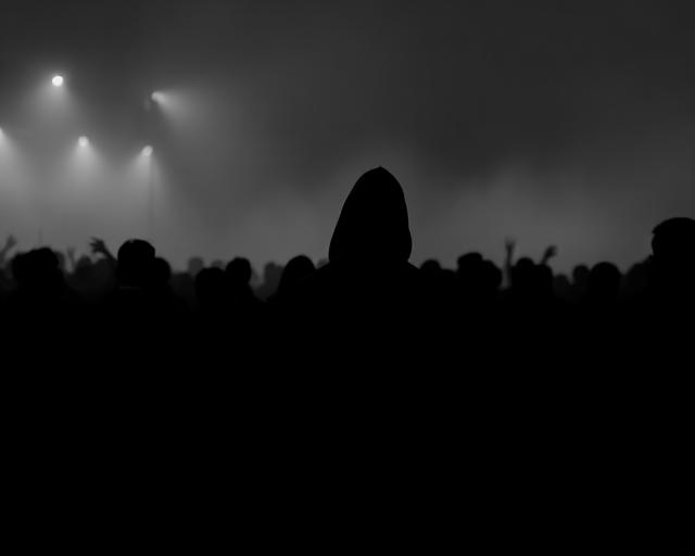 Person fading into a dark crowd