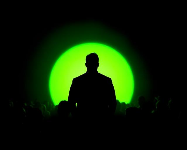 Leader silhouette with a lime halo before a crowd